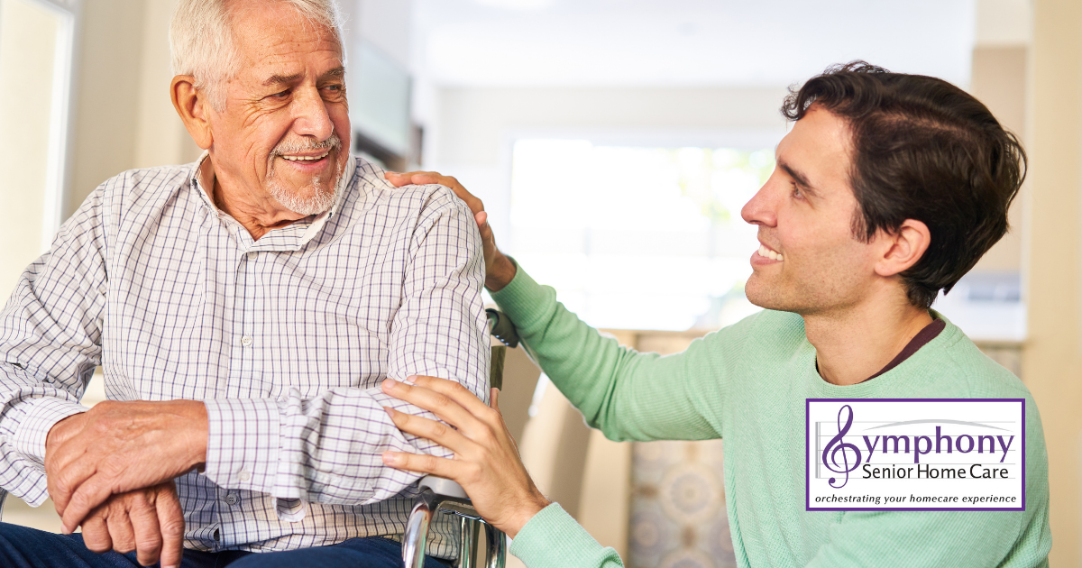 A loving son kneels beside his father, who is in a wheelchair, as they share a warm and joyful moment together.