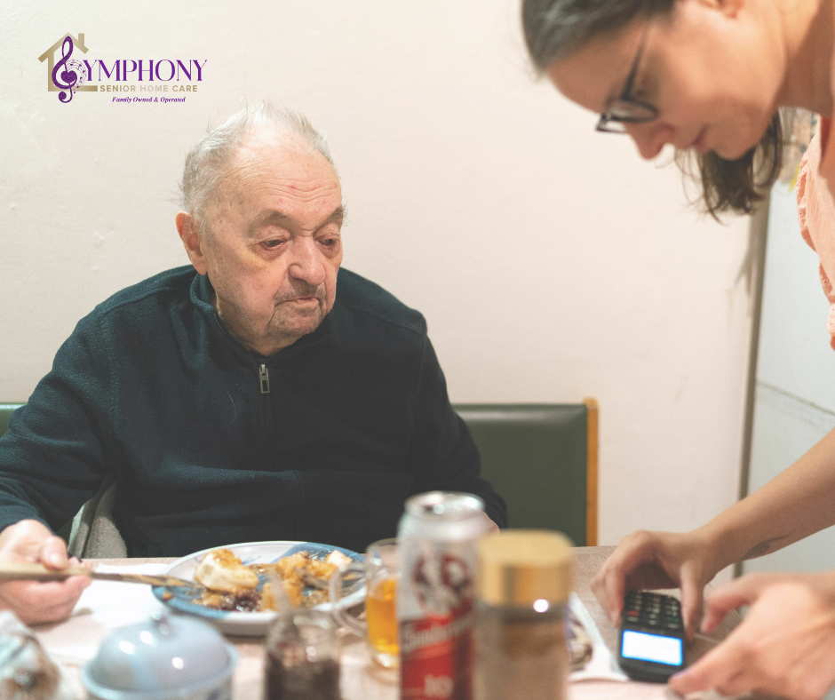 Caregiver assisting an older man during a meal at home, illustrating the kind of thoughtful support families look for when choosing a home care provider.