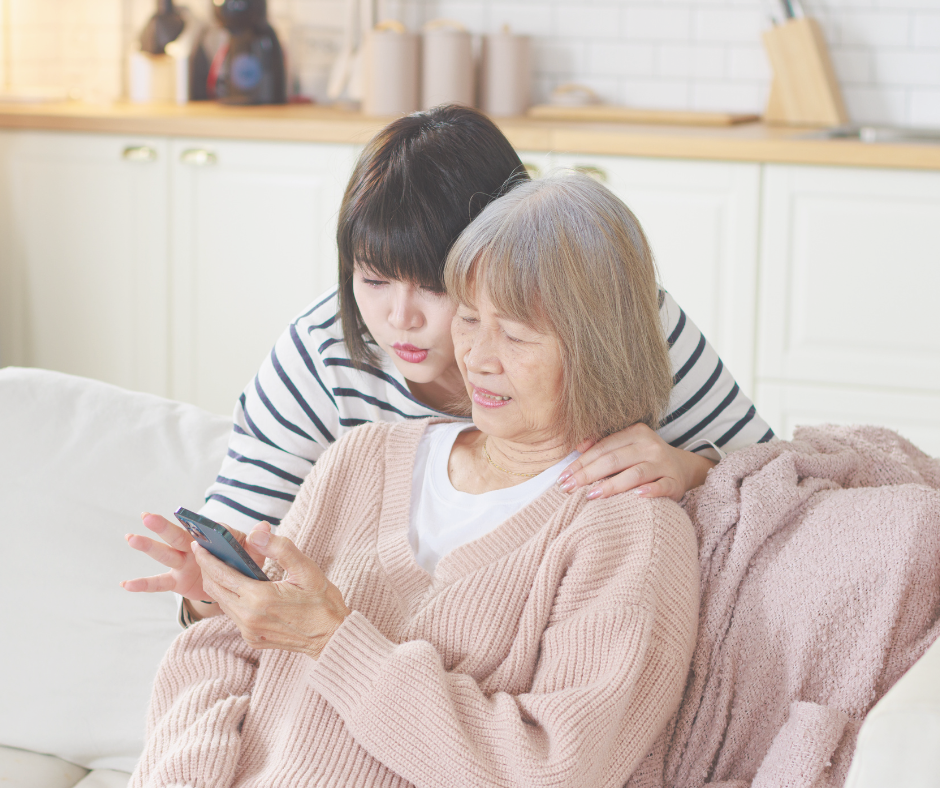 Adult daughter helping elderly parent call a home care agency for support at home